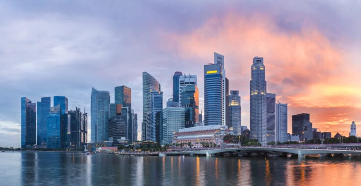 Singapore Skyline At Marina Bay At Twilight With Glowing Sunset Illuminating The Clouds