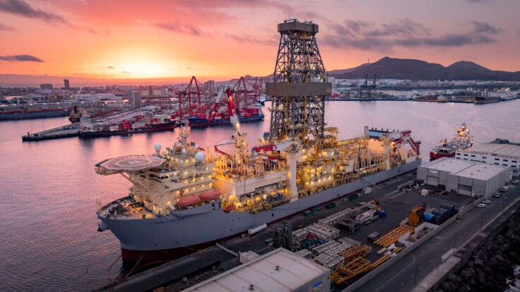 Offshore drilling rig in port at sunset